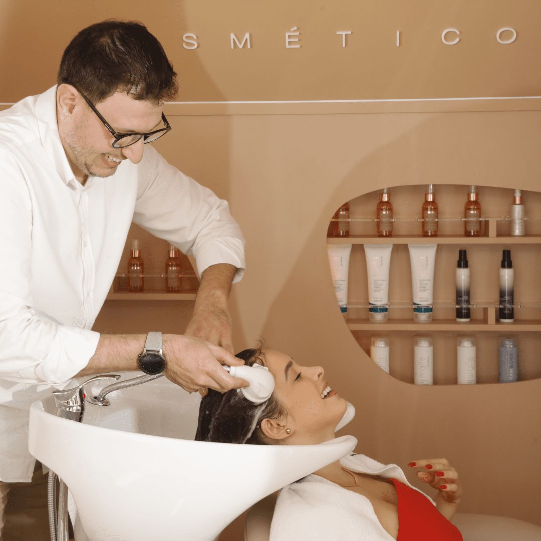 Cabeleireiro enxaguando o cabelo da cliente no lavatório