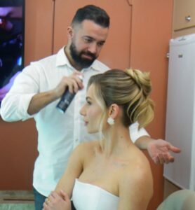Cabeleireiro finalizando penteado da modelo na Feira Bem Casados em Chapecó