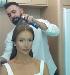 Cabeleireiro finalizando penteado da modelo na Feira Bem Casados em Chapecó