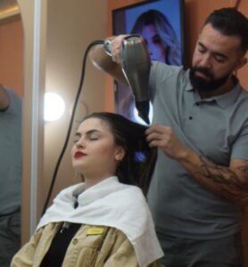 Cabeleireiro finalizando penteado da modelo na Feira Bem Casados em Chapecó